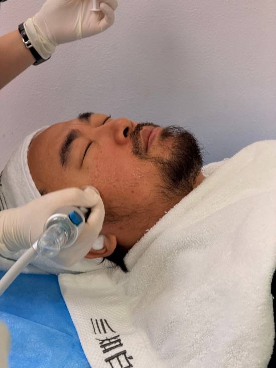 峰哥躺在医美操作床上,面部敷有面膜