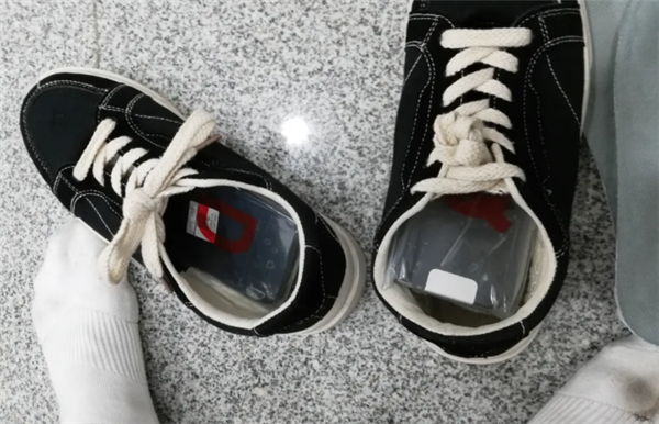 Two individuals apprehended for smuggling 8 iPhones hidden in their shoe soles due to abnormal gaits